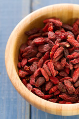 berries goji in bowl on blue wooden background