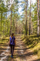 Young attractive woman walking through forest.