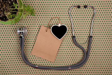 stethoscope, blank blackboard in the form of heart, shopping bag