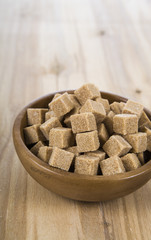 Pieces of brown sugar in a wooden bowl