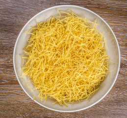Homemade noodles in a bowl on wooden background