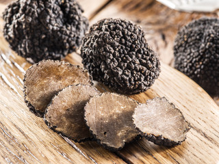 Black truffles on the old wooden table.