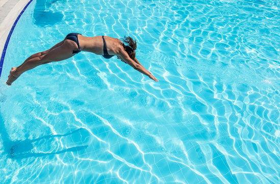 Woman Jumping Into The Swimming Pool.