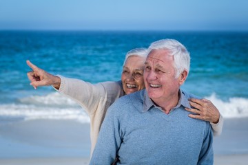 Senior couple embracing and pointing