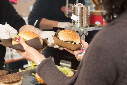 Beef burgers being served on food stall on open kitchen international food festival event of street food.