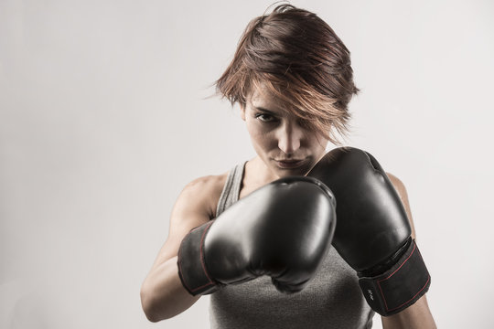 donna boxer sta per sferrare un pugno con i suoi guantoni neri