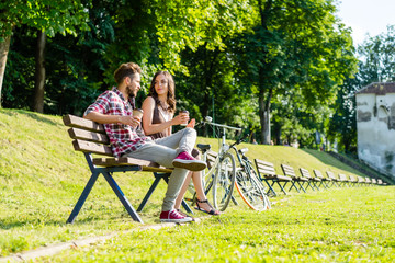friends taking a rest from biking in park