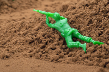 Fototapeta na wymiar plastic soldier in soil