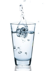 Water glass with splashing water and waterdrops