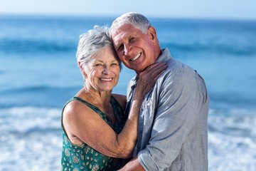 Fototapeta na wymiar Senior couple embracing at the beach