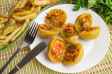 Spicy green tomatoes stuffed with parsley, hot pepper, garlic on a white plate