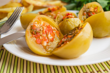 Spicy green tomatoes stuffed with parsley, hot pepper, garlic on a white plate