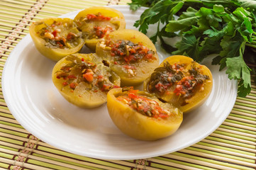 Spicy green tomatoes stuffed with parsley, hot pepper, garlic on a white plate