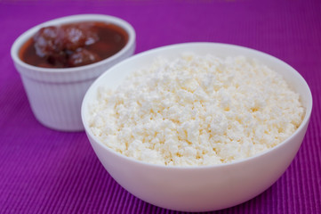 Cottage cheese in white bowl with strawberry jam