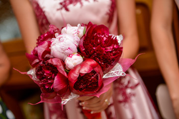 Bride holding a red flower bouquet
