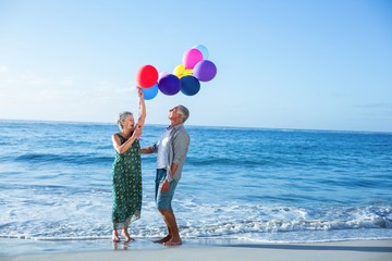 Senior couple holding balloons 