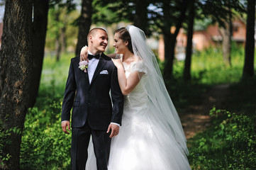 Naklejka premium Stylish newlyweds stay on park and hugging.
