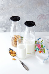 fresh homemade almond milk in a transparent bottle and almonds.