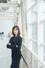 Attractive asian business woman smiling outside office