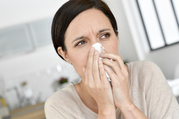 Woman blowing her nose, having allergy