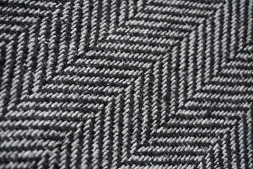 Detail of a modern woolen purse with black and white lines in the shape of arrows (fish bone pattern)