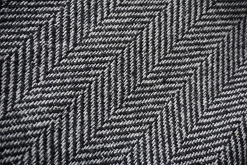 Detail of a modern woolen purse with black and white lines in the shape of arrows (fish bone...
