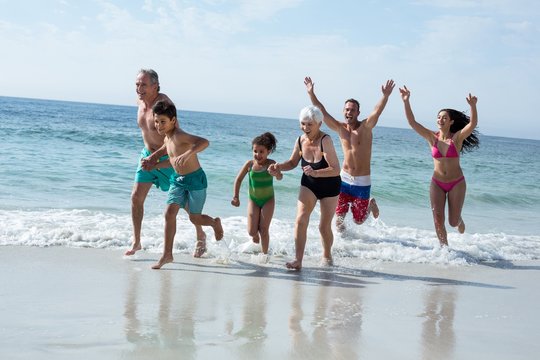 Multi-generation family running at beach 