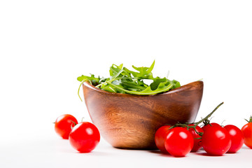 salad in a wooden salad bowl. Tomato, mozzarella and basil isolated on white background