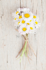 Obraz premium Bouquet of daisies on white wooden background