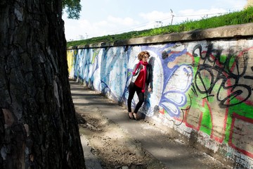 Gorgeous brunette woman posing with graffiti on the street...