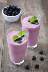 Blueberry smoothie in a glass on a rustic table
