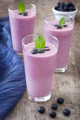 Blueberry smoothie in a glass on a rustic table
