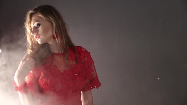 Girl in long red  dress posing in smoke