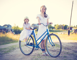 Obraz premium Beautiful mother and daughter traveling on a bicycle.