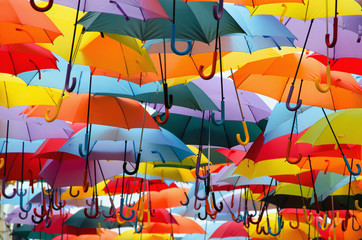 Fototapeta na wymiar Colorful umbrellas hanging above the street