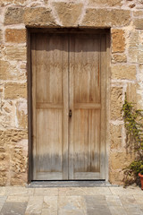 wooden door in stone wall and flowerpot, mediterranean style