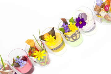 mini canapes in plastic cups decorated with edible flowers