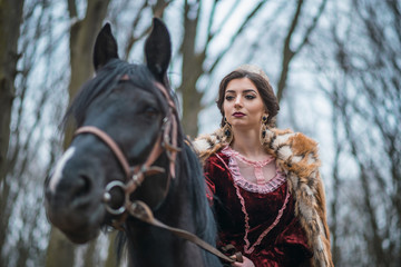 Princess with her horse in the woods