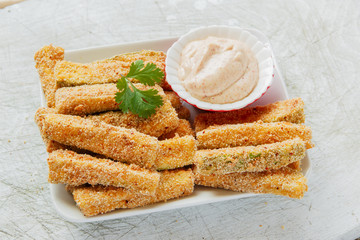 Fried zucchini breaded cheese and white sauce