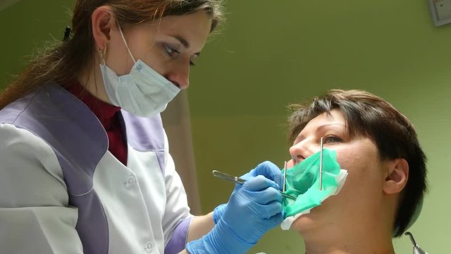 4k Dentist doing a dental treatment on a female patient