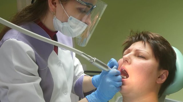 4k Dentist making professional teeth cleaning female patient at the dental office