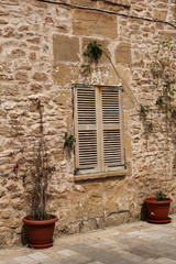 Fototapeta na wymiar window with wooden shutter and stone wall, mediterranean style