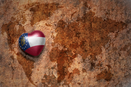 heart with georgia state flag  on a vintage world map crack paper background