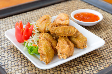 fried chicken wings on wicker tray.