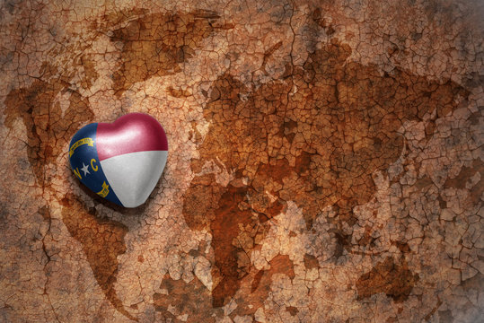 heart with north carolina state flag  on a vintage world map crack paper background