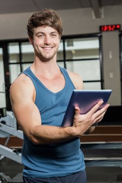 Portrait of gym trainer using a digital tablet