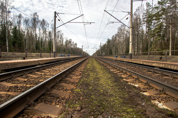 Naklejka premium Parallel to the railway tracks at a station in the countryside