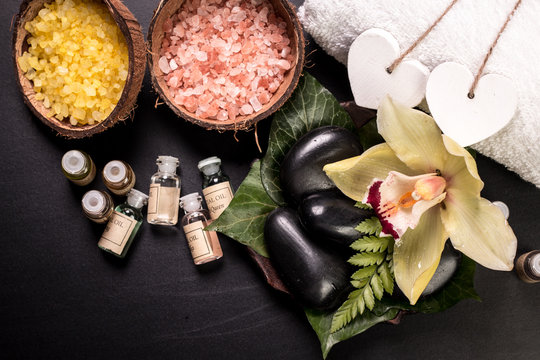 spa concept with stones, flowers , essential oils and mineral salt  on wooden table