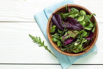 Fresh green salad with spinach ,ruccola,lettuce on wooden table.
