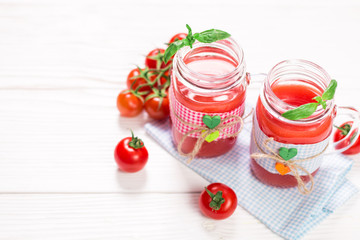 Tomato Juice and Fresh Tomatoes on a White Wooden Background